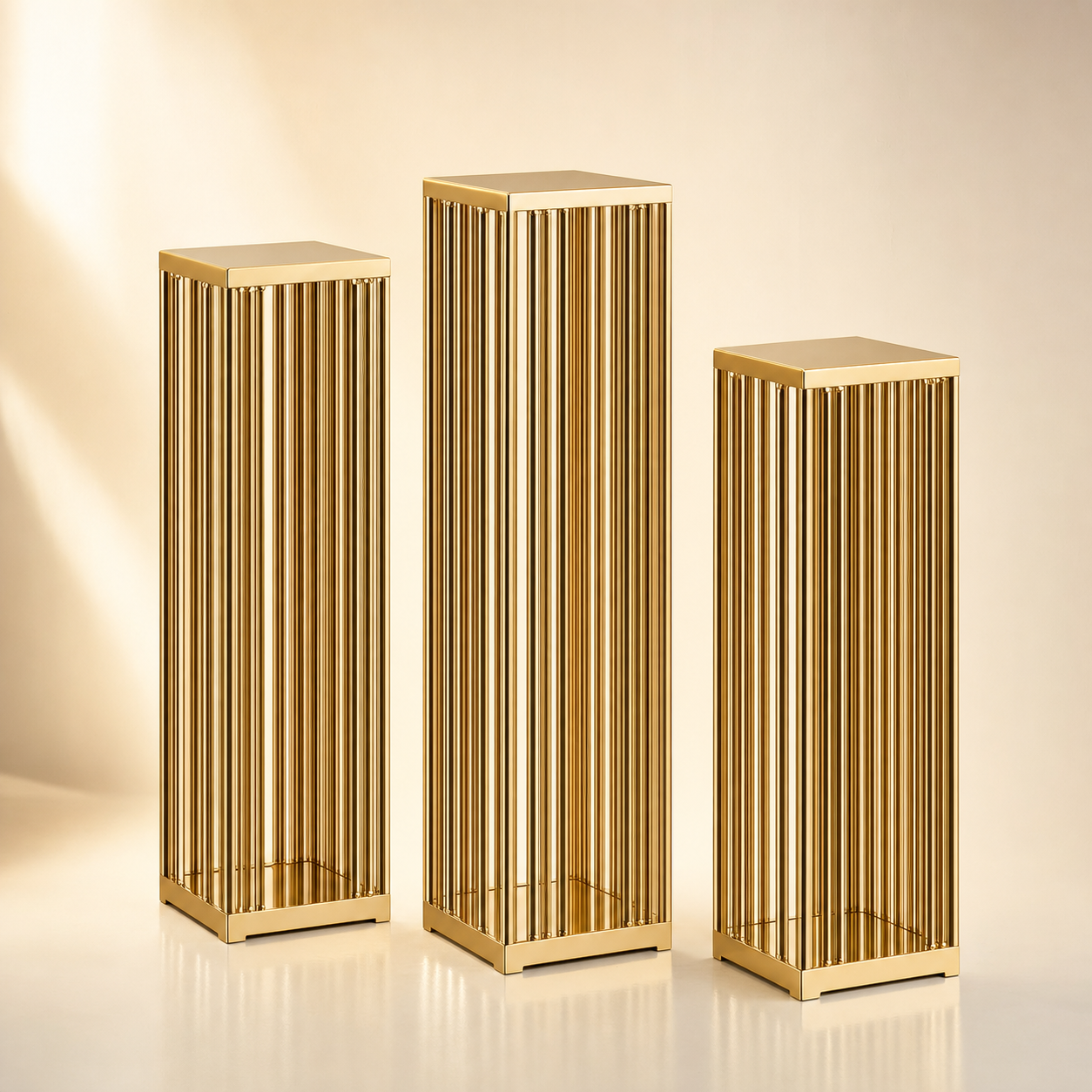Trio of tall gold reeded pillar plinths in varying heights